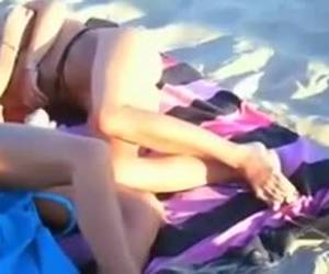 Horny couple is having sex on the beach while their friends are watching them in action